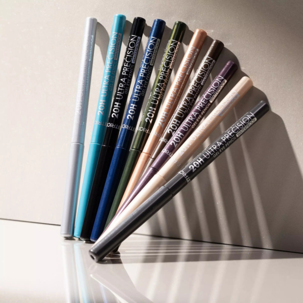 Neuf crayons Catrice 20H Ultra Precision Gel Waterproof Crayon Yeux Gel 0,08 g, chacun dans une teinte métallique ou mate unique, sont disposés en une rangée ordonnée sur une surface légère et réfléchissante avec des ombres douces. Dakar
