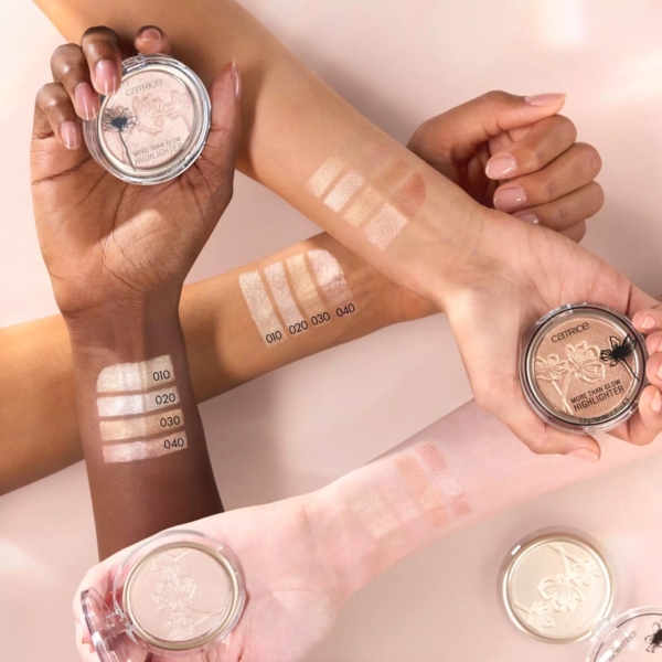 Trois mains de carnations différentes présentent des échantillons de quatre nuances de Catrice More Than Glow Highlighter Poudre Compacte Illuminateur 5,9 g, chacune tenant un compact rond pour mettre en valeur le fini chatoyant et la variété des couleurs du produit. Dakar