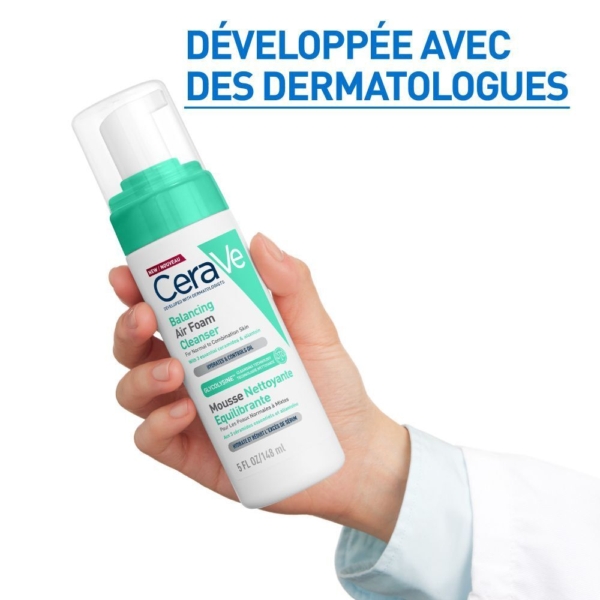 Une main tient un flacon de CeraVe Mousse Nettoyante Équilibrante 148 ml sur un fond blanc, avec "Développée avec des dermatologues" en français bleu au-dessus. Dakar