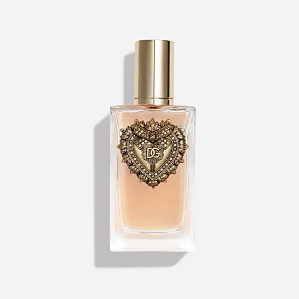 Flacon de parfum en verre transparent contenant un liquide rose pâle, orné d'un emblème en forme de cœur doré sur le devant et d'un bouchon doré brillant, sur un fond blanc uni. Dakar