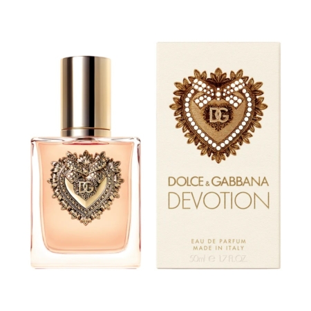 Un flacon de 50 ml de Dolce & Gabbana Devotion Eau de Parfum, orné d'un emblème en forme de cœur doré, se trouve à côté de son coffret assorti, tous deux ornés du cœur décoratif emblématique et d'un texte doré élégant. Dakar