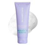 Un tube lavande de "In HairCare Shampoing doux Wash n' care nourrit et fortifie 250ml" se tient debout sur un fond blanc mousseux. Dakar