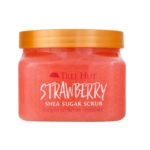 Un pot de Gommage corporel à la fraise et au sucre de karité 510 g avec un couvercle orange doré, montrant le gommage rose à l'intérieur. L'étiquette indique le nom du produit et son poids (510 g). Dakar