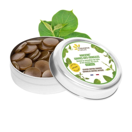 Une boîte ronde de pastilles Fleurance Nature avec un dessin de feuilles vertes sur l'étiquette, ouverte pour révéler des gommes circulaires brunes à l'intérieur. Une feuille verte est placée derrière la boîte sur un fond blanc. Dakar