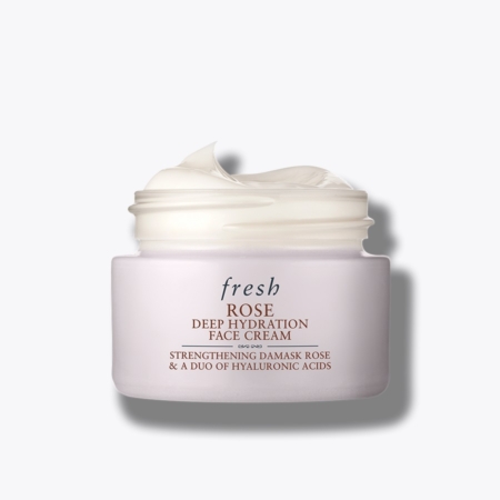 Un pot rose clair de Fresh Rose Deep Hydration Crème hydratation Rose 50ml (Copie) est posé avec son couvercle, révélant un hydratant blanc crémeux. Les détails du produit apparaissent en rouge foncé et en texte doré sur le pot. Dakar