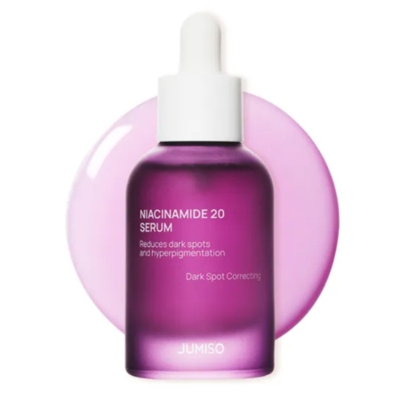 Un flacon violet de Jumiso Niacinamide 20 Serum avec un bouchon compte-gouttes blanc, placé devant une éclaboussure de liquide violet clair. L'étiquette met en avant les bénéfices pour les taches brunes et l'hyperpigmentation. Dakar