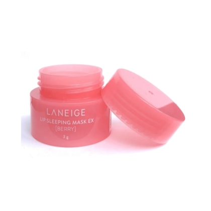 Un petit pot rose de Laneige Lip Sleeping Mask EX (Berry) avec le couvercle enlevé et placé à côté, montrant le produit crémeux à l'intérieur. Le pot est étiqueté avec un texte blanc et contient 3 grammes. Dakar