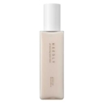 Un flacon rectangulaire beige avec un bouchon blanc portant l'inscription "NEEDLY pH Balancing Toner Lotion" en texte vertical. Le design minimaliste présente des lignes épurées et des couleurs douces. Dakar