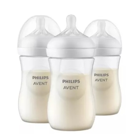 Trois biberons Philips Avent remplis de lait, chacun muni d'une tétine en silicone transparent et d'un bouchon blanc, sont disposés à proximité les uns des autres sur un fond blanc. Dakar