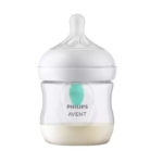 Un biberon Philips Avent rempli de lait, avec un corps transparent, un bouchon blanc, une tétine en silicone et un évent anti-colique vert à l'intérieur. Dakar