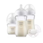 Trois Philips Avent Natural Response Kit Nouveau-Né Biberons Verre SCD878/11, deux grands et un petit, remplis de lait, ont des tétines en silicone transparent et des couvercles blancs. Une tétine blanche avec un couvercle se trouve devant. Dakar