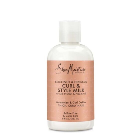 Une bouteille blanche de SheaMoisture Coconut & Hibiscus Curl & Style Milk avec une étiquette rose pâle, conçue pour les cheveux épais et bouclés. La bouteille a une contenance de 8 fl oz et prétend hydrater, définir les boucles, être sans sulfate et sans danger pour les couleurs. Dakar