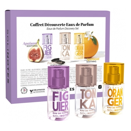 Un coffret de découverte des Eaux de Parfum Solinotes avec trois petits flacons de parfum à l'avant : Figue (violet), Tonka (beige) et Orange (orange). L'emballage présente des images de fruits et un motif floral. Dakar