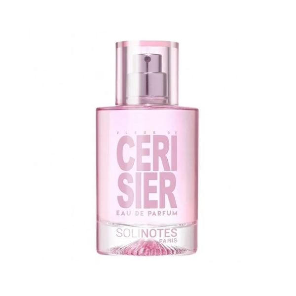 Un flacon de parfum rose transparent étiqueté "Solinotes Eau De Parfum Fleur De Cerisier 50 ml pour Femme", avec un embout argenté et un bouchon rose transparent, est présenté sur un fond blanc uni. Dakar