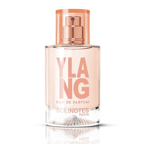 Un flacon en verre transparent avec un bouchon pêche contient Solinotes Eau De Parfum Ylang 50 ml pour Femme. L'étiquette frontale affiche "YLANG EAU DE PARFUM" en gros caractères et "SOLINOTES PARIS" en lettres plus petites. Dakar