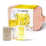 Un coffret Solinotes Vanille comprenant une trousse de toilette rose, un coffret jaune et blanc, un flacon de parfum, un vaporisateur et un pain de savon beige avec le nom de la marque et un cœur en relief. Dakar