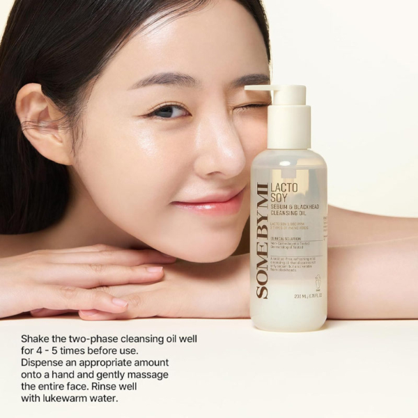 Une femme souriante à la peau rosée fait un clin d'œil tout en tenant un flacon de Some By Mi Huile Nettoyante Douce Équilibrante Lacto Soy Sebum & Blackhead 200 ml. Le texte ci-dessous explique comment nettoyer et utiliser efficacement le produit. Dakar