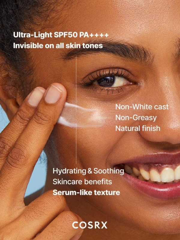 Une femme souriante applique Cosrx Crème Solaire Spf50 Invisible Ultra Légère 50 ml sur sa joue. Le texte mentionne son SPF 50 PA++++ ultra-léger, invisible sur toutes les carnations, sans traces blanches, non gras, hydratant, apaisant et au fini semblable à celui d'un sérum. Dakar