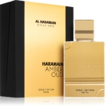 Un flacon rectangulaire doré étiqueté "Al Haramain Amber Oud Gold Edition 100ml" se trouve devant un coffret noir et or assorti portant le texte "Al Haramain Since 1970". Le flacon contient 100 ml. Dakar