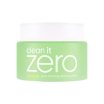 Un pot vert avec un couvercle blanc contient Banila Baume Nettoyant 3 en 1 Clean It Zero Tea Tree Ex 100 ml, un baume nettoyant qui clarifie les pores dans un emballage minimaliste. Dakar