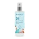 Un flacon pulvérisateur transparent étiqueté "Berdoues Coco Fragrance Mist" avec des accents bleus et orange, debout. Le flacon contient 200 ml et revendique 95 % d'ingrédients d'origine naturelle. Dakar