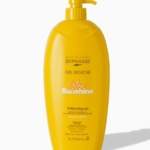 Une bouteille jaune de 2 litres de gel douche Byphasse Glow Sunshine avec un distributeur à pompe, comportant un texte blanc et orange et étiqueté comme contenant des prébiotiques pour hydrater et nourrir la peau. Dakar
