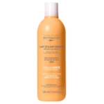 Un flacon orange de Byphasse Whitening Effect Brightening Milk, 500 ml, à base d'extraits de carotte, de kiwi, d'AHA, de glycérine et d'esters de jojoba, conçu pour le visage et le corps. Dakar
