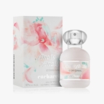 Un flacon du parfum Anaïs Anaïs L'Original de Cacharel se trouve à côté de sa boîte à motifs floraux. Le flacon est blanc avec un bouchon argenté et un étiquetage pastel, tandis que l'étui est orné de fleurs d'aquarelle rose tendre. Dakar
