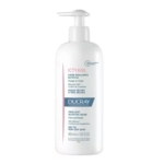 Un flacon pompe blanc étiqueté "Ducray Ictyane Emollient Nutritive Cream" pour le visage et le corps, convenant aux peaux sèches à très sèches, avec des accents bleus et roses, contenant 400 ml (13.5 fl. oz). Dakar