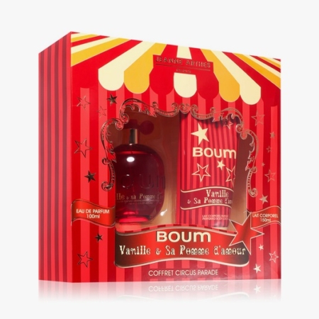 Un coffret cadeau rouge et jaune sur le thème du cirque contenant un flacon de parfum BOUM Vanille & Sa Pomme d'Amour et un lait corporel assorti de Jeanne Arthes. L'emballage est orné d'étoiles et de rayures de carnaval. Dakar