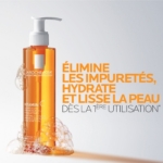 Un flacon de nettoyant à la vitamine C de La Roche-Posay avec de la mousse et des bulles autour de la base. Le texte en français se lit comme suit : "Élimine les impuretés, hydrate et lisse la peau dès la 1ère utilisation. Dakar