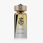 Un flacon de parfum de luxe avec un bouchon en or texturé et un corps dégradé d'or à argent. Le flacon présente une calligraphie arabe noire audacieuse, le mot "KHAIR" et l'étiquette "FELICITY PARIS CORNER". Dakar
