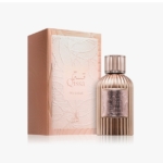 Un flacon de parfum "Qissa Delicious" au design élégant, nervuré et métallique se trouve à côté de son coffret assorti, rose blush et gaufré, décoré de délicats motifs de feuilles. Dakar