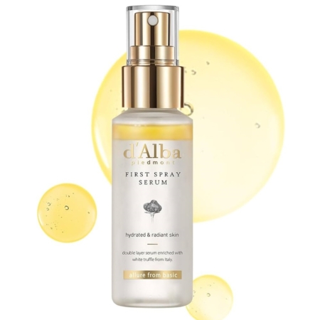 Un flacon de 100 ml de D'Alba White Truffle First Sérum Brume à la Truffe Blanche avec une pompe dorée et transparente, placée devant des gouttelettes de liquide jaune. L'étiquette met en avant la truffe blanche italienne pour une peau hydratée et éclatante. Dakar