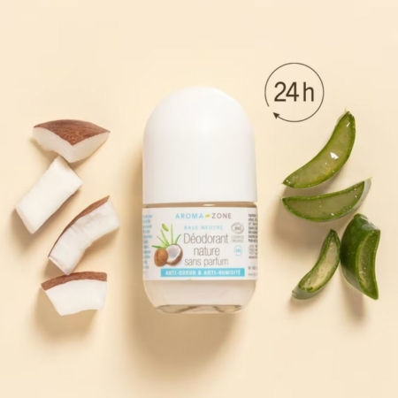 Un flacon de déodorant roll-on est placé entre des tranches de noix de coco à gauche et des tranches d'aloe vera à droite, avec une icône "24h" au-dessus, sur un fond beige. Dakar