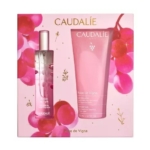 Un coffret cadeau Caudalie Rose de Vigne comprenant un vaporisateur de parfum rose et un tube de gel douche rose assorti, présentés sur un fond rose avec des raisins et des accents dorés. Dakar