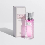 Un flacon en verre rose du parfum Miss Dior Blooming Bouquet se trouve à côté de sa boîte rectangulaire assortie avec des accents argentés et blancs, tous deux étiquetés avec le nom du produit. Dakar