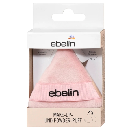 Une houppette de maquillage et de poudre ebelin emballée, de forme triangulaire, de couleur rose pâle, avec un bracelet rose et le logo "ebelin" en noir, présentée dans une boîte beige et blanche avec un texte en allemand. Dakar