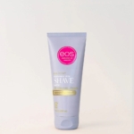 Un tube d'EOS Beurre à Raser Parfum Cachemire 207 ml avec du beurre de karité se tient debout sur un fond clair uni, mettant en valeur un emballage lavande avec des accents roses et jaunes et un texte blanc. Dakar