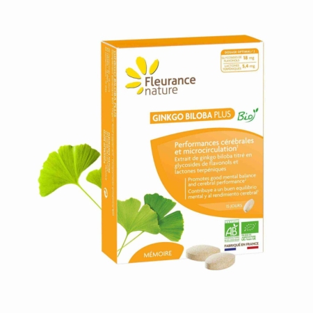 Une boîte de suppléments Fleurance Nature Ginkgo Biloba Plus est représentée avec deux comprimés et deux feuilles de ginkgo vertes à côté. L'emballage est principalement blanc et orange, avec des informations sur le produit et ses avantages en français. Dakar