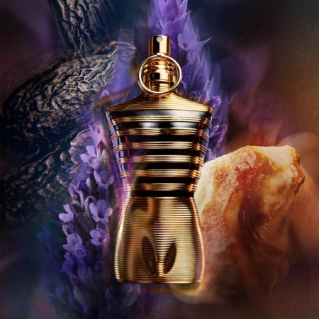 Un flacon de parfum sculpté en or avec des stries horizontales est placé sur un fond de fleurs de lavande, une gousse de vanille à la texture sombre et un morceau de résine d'ambre, créant ainsi une atmosphère luxueuse et aromatique. Dakar
