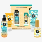 Un coffret de quatre produits de soin au design floral, dont les flacons et tubes sont étiquetés "Fleur de Tiaré". Le coffret comprend une eau de toilette, un gel douche, une brume scintillante et une lotion pour le corps. Dakar