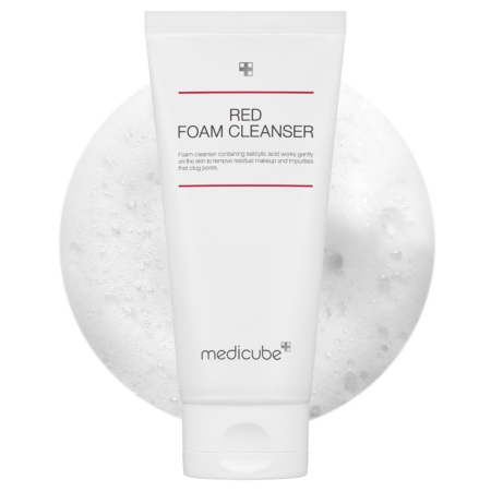 Un tube blanc étiqueté "Red Foam Cleanser" de Medicube est présenté devant un fond texturé et mousseux. Le tube présente un design minimaliste avec un texte rouge et gris. Dakar