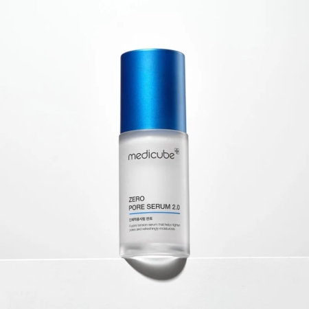Un flacon en verre givré de Medicube Zero Pore Serum 2.0 avec un bouchon bleu métallique, posé à la verticale sur une surface blanche avec une ombre portée derrière lui. Dakar