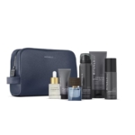 Une trousse de toilette Rituals bleu marine est présentée avec six produits de soin et de toilette Rituals, dont des flacons, des tubes, un sérum compte-gouttes, un petit pot et un déodorant en spray, bien rangés devant la trousse. Dakar