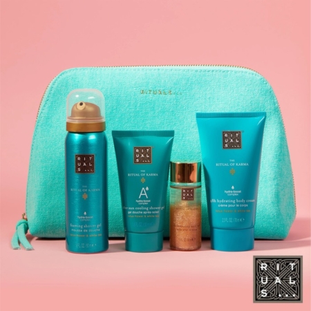 Une trousse de toilette Rituals turquoise est présentée derrière quatre produits pour le bain et le corps Ritual of Karma sur fond rose : un gel douche moussant, un gommage pour le corps, une huile chatoyante et une crème hydratante pour le corps. Dakar