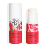 Un tube blanc et rose corail de Roger & Gallet Wellbeing Solid Fragrance dans la senteur "Gingembre". L'un des tubes est fermé et l'autre présente le bâton de parfum solide partiellement déployé. Dakar