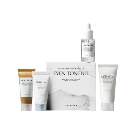 Le Kit Skin1004 Unifiant le Teint à la Centella de Madagascar comprend quatre tubes blancs et un flacon compte-gouttes aux étiquettes minimalistes, tous disposés autour de la boîte principale du kit. Dakar