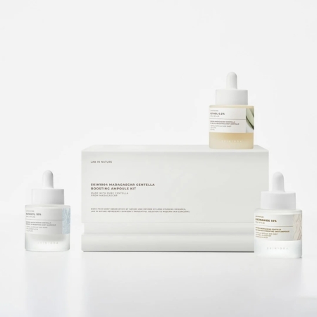Trois flacons compte-gouttes du Coffret d'Ampoules pour Éclat et Anti Age à la Centella de Madagascar 3 pièces de Skin1004 sont présentés sur un fond blanc, dans un emballage minimaliste avec de subtiles étiquettes colorées pour un look moderne. Dakar