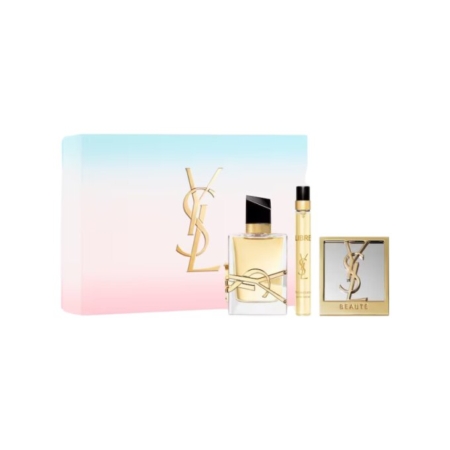 Un coffret cadeau de parfum YSL avec une boîte pastel dégradée, un logo YSL doré, un flacon de parfum, un vaporisateur de voyage et un miroir compact présenté devant. Dakar